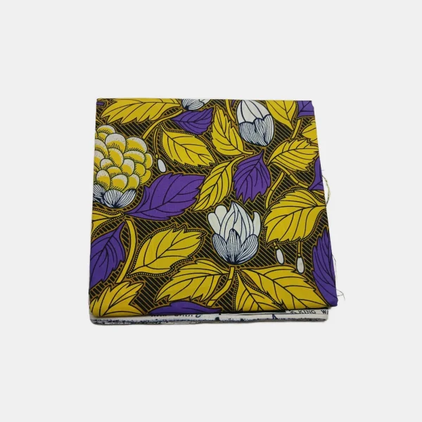 Folded Purple Lily Crown Ankara fabric, 100% cotton, featuring yellow and purple leaves on a black background.