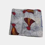Folded Crimson Currents Ankara fabric, 100% cotton, showing the red, navy, and white flowing pattern.